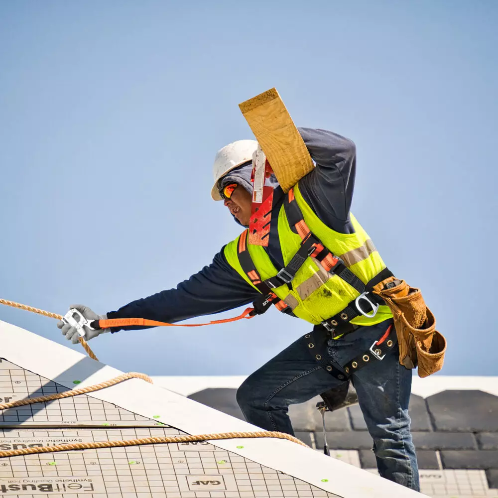 construction worker on roof wearing fall protection